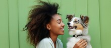 Young Woman Of African Descent Admires Comical Print Of Dog Playfully Emulates Kissing Gesture Against Light Green Backdrop Outdoor Portrait Of Attractive