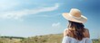 © HN Works - Happy woman in white shirt and summer hat looking at sky in back view photo with ample copy space