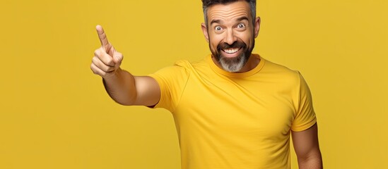 Poster - Happy man gesturing to empty space with hands offering advertising opportunities isolated on yellow background