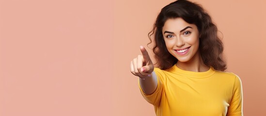 Poster - Happy teenage girl pointing and smiling drawing attention to an object in empty area