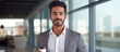 © HN Works - Arabian man holding coffee cup confident standing by glass wall in office and looking at camera