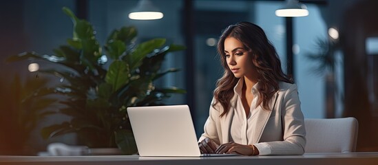 Poster - A female Caucasian entrepreneur working at her office desk on a laptop computer