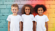 group of children wearing white t-shirts standing in front of colorful wall together, photo of girls and boys for apparel mock-up, smiling toddlers, preschool