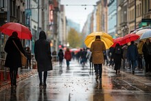 Lots Of People With Umbrellas And Waterproof Clothing. Street View On A Rainy Autumn Day.