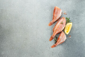 Wall Mural - fish, red snapper with lemon, rosemary, salt on a light background. Healthy food concept. place for text, top view