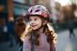 © CreativeArt - Little girl riding a bike on an asphalt road in the city, wearing a protective helmet