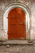 Old arched wooden entrance door to historic church