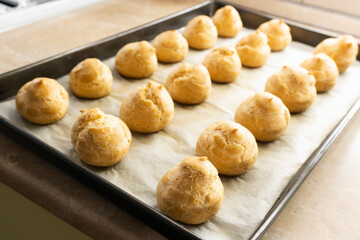 Freshly baked profiteroles on a plate. food concept. dessert. bakery.