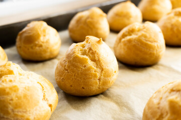 Wall Mural - Freshly baked profiteroles on a plate. food concept. dessert. bakery.