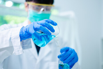 Wall Mural - Close up of Female scientist or researcher is pouring blue substance or liquid in to a sample test tube. Concept of science, biochemistry, chemical, biotechnology laboratory. Analyzing and experiment