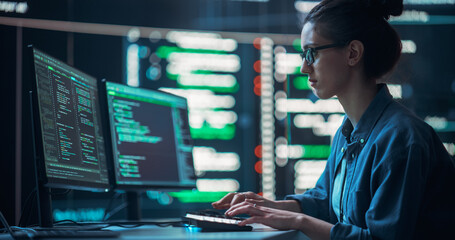 Fototapete - Medium Shot of a Woman Working as a Developer, Surrounded by Big Screens Displaying Lines of Code in a Monitoring Room. Female Programmer Using Desktop Computer, Analysing Data, Creating AI Software