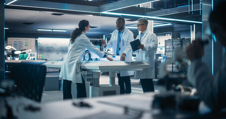 Fototapete - Industrial Robotics Specialists Working on a Mobile Robot, Using a Tablet Computer. Male Engineer In Lab Coat Discussing an Automated AI Robotic Delivery Assistant with His Young Team
