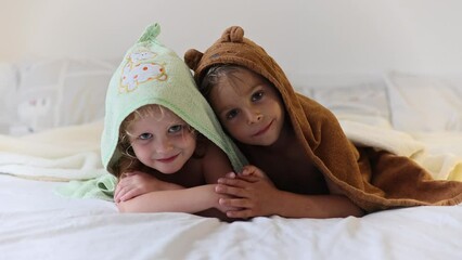 Poster - Two cute blond beautiful children, boy and girl, lying on the bed after bath, cuddling together