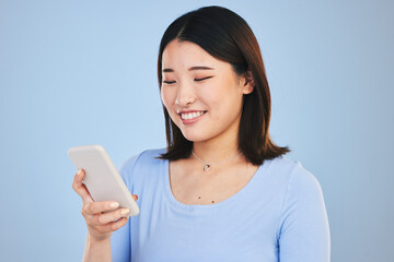 Poster - Happy asian woman, phone and typing in social media, networking or communication against a blue studio background. Female person smile in online research, chatting or texting on mobile smartphone app