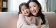 © Zaleman - Loving adult daughter sitting on sofa at home and hugging elderly mother, happy and smiling