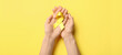 Leinwandbild Motiv Hands with golden awareness ribbon on yellow background. Cancer concept