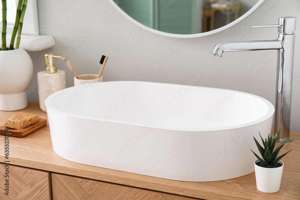 White sink with bath accessories on table in room