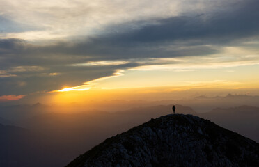 Single subject on the summit of the montanga at sunset - Scene of hiking in the mountains