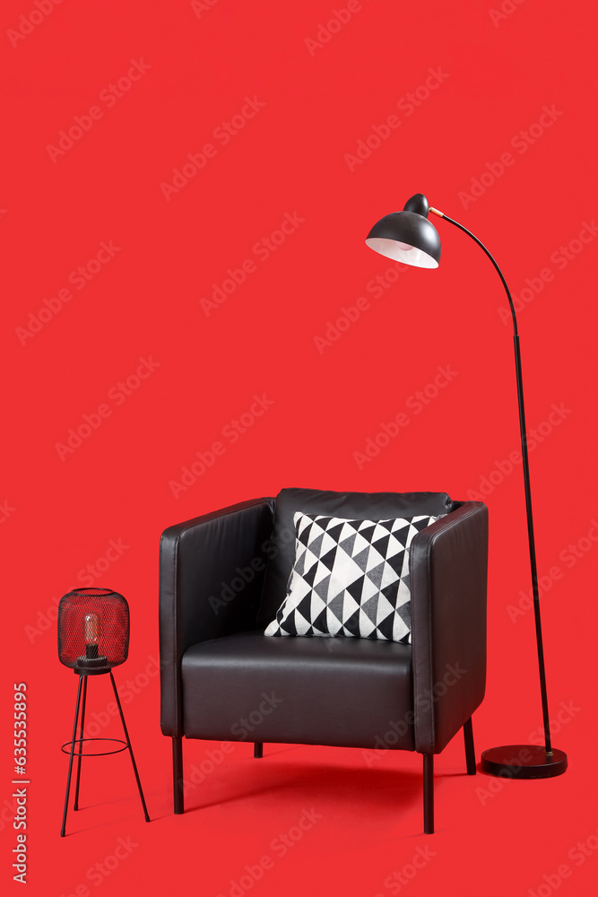 Black armchair and lamps on red background