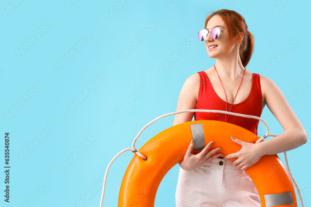 Female lifeguard with ring buoy on blue background