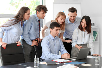 Canvas Print - Group of business consultants working with laptop at table in office