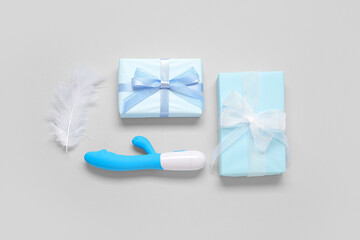 Composition with vibrator, feather and gift boxes on white background