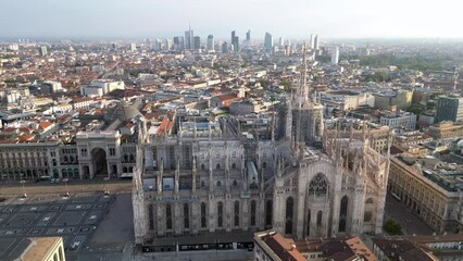 Wall Mural - Europe, Italy, Milan - Aerial view of Piazza Duomo, gothic Cathedral in downtown center city. Drone aerial view of the gallery and rooftops during sunrise - Duomo Unesco Heritage sightseeing 