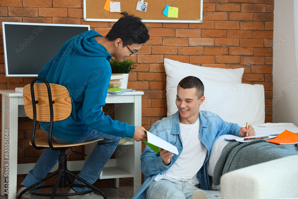 Male students doing homework in dorm room