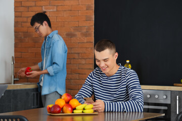 Wall Mural - Male student using mobile phone in dorm kitchen