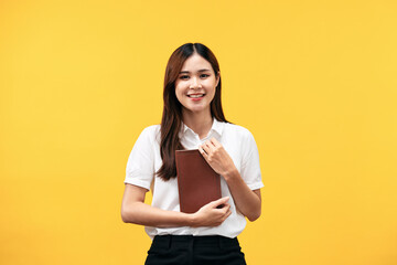 Young asian woman wearing white short sleeve shirt and holds holy bible to learning and praying to god