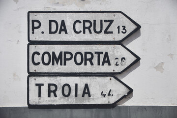 road signs in melides, alentejo, directing the way to pinheiro da cruz, comporta, and troia.