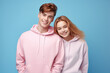 © Surachetsh - Close-up portrait of young loving couple embracing while standing in studio. Couple in athletic sweater. Photo shoot of lovely couple sweater. Generative AI.