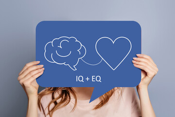 iq eq concept. girl holding poster with hand drawing a brain and heart