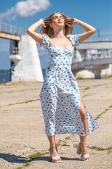 Wall Mural - Portrait of a young beautiful blonde woman in a white summer dress