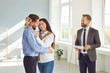 © Studio Romantic - Happy young family received key to new apartment. Smiling real estate agent is happy to satisfy all the needs of clients with the purchase of property. Mortgage of real estate, purchase of housing.