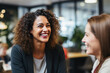 © Petr - Young attractive woman smiling, talking to her female colleague in business environment. Concept for teamwork, brainstorming ideas, positive work attitude. Working professionals.