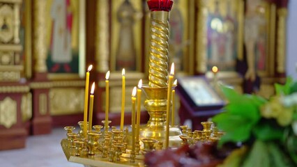 Wall Mural - A golden candlestick with burning candles in the church on the altar.