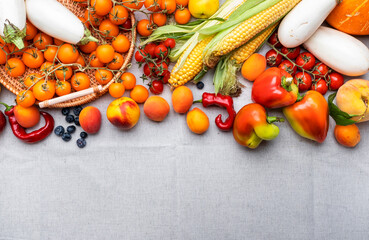 Wall Mural - Autumn orange, yellow, red vegetables and fruits set, apricots, cherry tomatoes, corn, etc. on gray linen background, top view