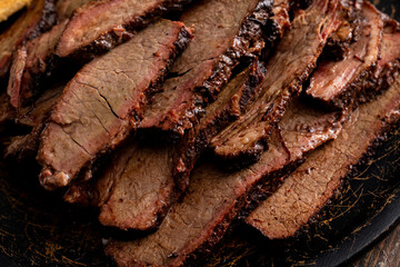 Sliced smoked brisket on a serving plate with toast