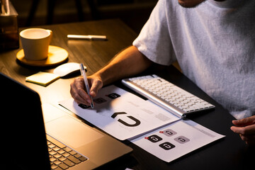 Asian man graphic designer working on computer drawing sketches logo design. The concept of a new brand. Professional creative occupation with idea.