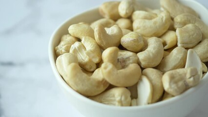 Canvas Print - cashew nuts in a small bowl on black color background 