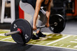 © Dusan Petkovic - Close up of a fit female bodybuilder lifting heavy barbell in a gym.