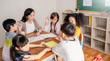 © paulaphoto - Group of pupil boy girl group study with teacher in classroom at elementary school. Student in primary school story telling. Children  classroom. Education knowledge, success teamwork concept banner
