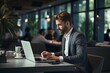 © BajimBa - A businessman in the office is sitting at his desk and laptop.