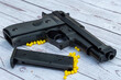 © Philipimage - airsoft handgun with yellow bb, on white wooden background