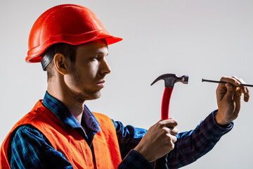 Man builder. Hammer hammering. Builder in helmet, hammer, handyman, builders in hardhat. Hammer hand nail. Male's hands holding a hammer and a nailing. Hammering a nails, hands only