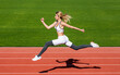 © Yevhen - Runner. Professional sportswoman during running training session. Woman running jump on stadium track. Sportswoman in sportswear jumping