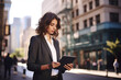 © Planetz - Young business woman standing on big city street outside using digital tablet device