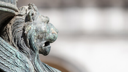 Wall Mural - Venice, Italy - Ancient decoration element of a scary lion head with wings in Venice historical and touristic downtown, San Marco square, Italy, closeup, details, with copy space blurred background