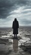 A hooded man standing in a desolate landscape